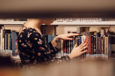 Photo d'une fille qui cherche un livre bibliothèque