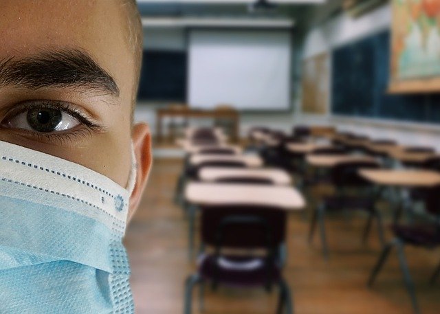 Photo d'un étudiant avec un masque dans une salle d'examens
