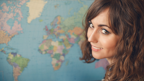 Photo d'une étudiante devant une carte du monde